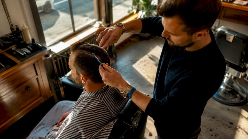 Barber cutting man's hair in walk-in shop