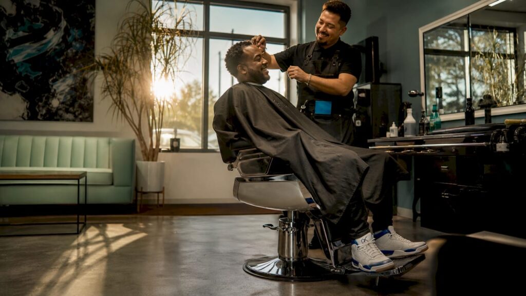 Man getting haircut from barber in shop