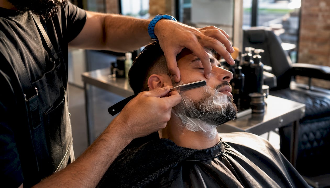 Barber using straight razor for close shave