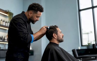 Barber examining man's scalp at barbershop