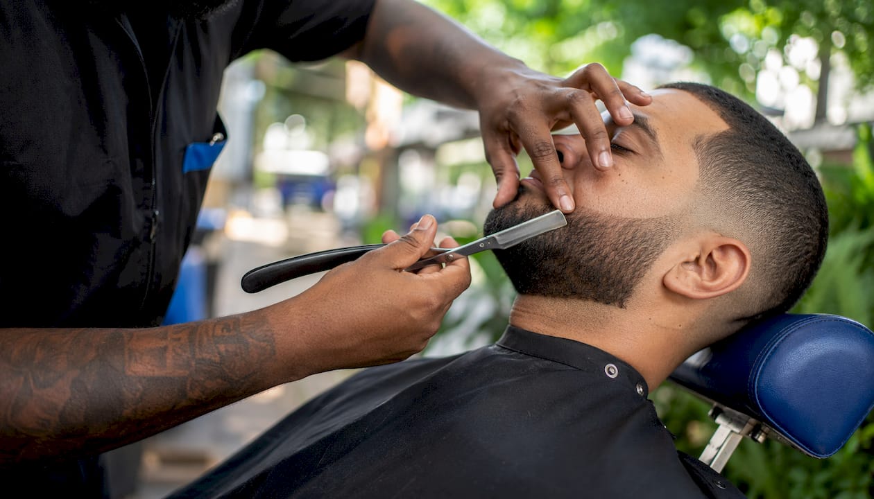 Close-up of straight razor shaping beard edge