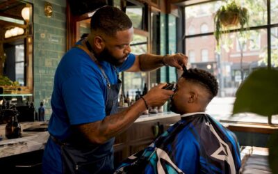 Barber performing mid skin fade haircut