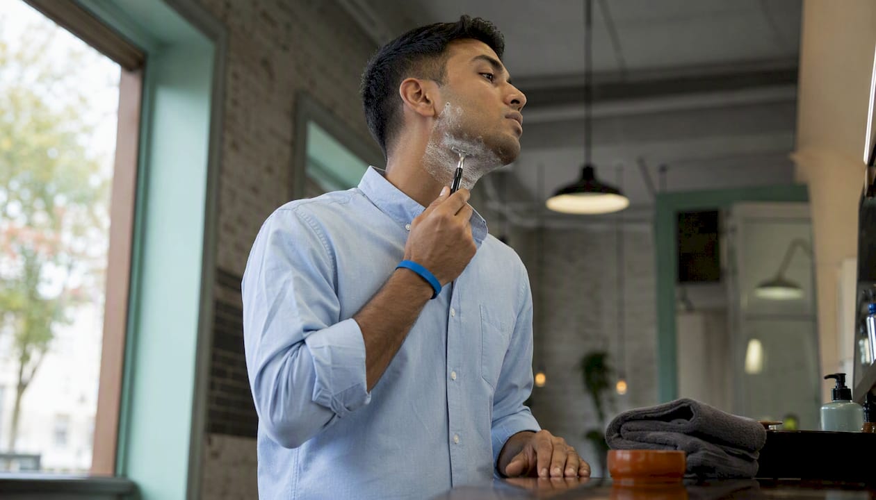 Man shaving neck along hair growth direction