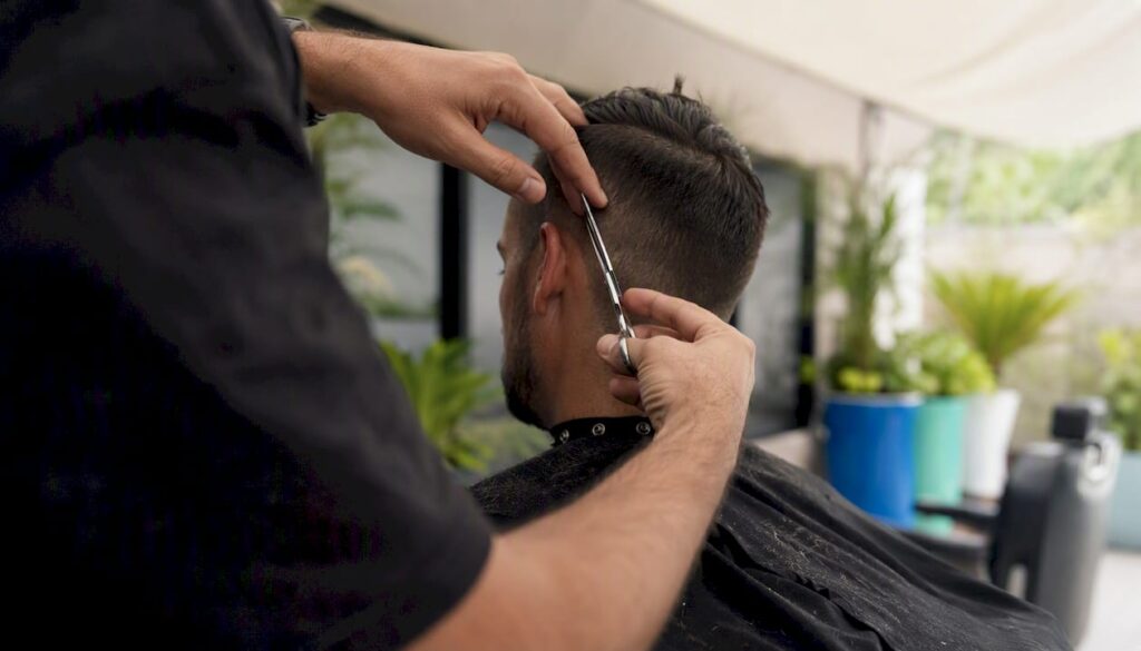 Barber performing precision haircut with scissors